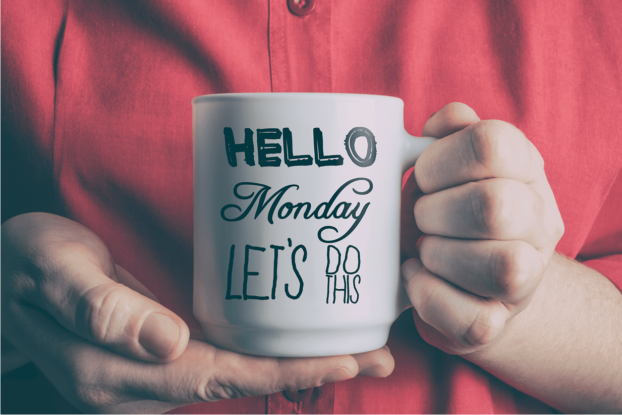 Person holding mug with Monday motivation message.