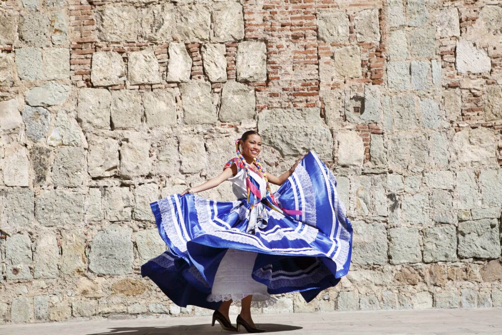 Dancer twirling in vibrant blue traditional dress.
